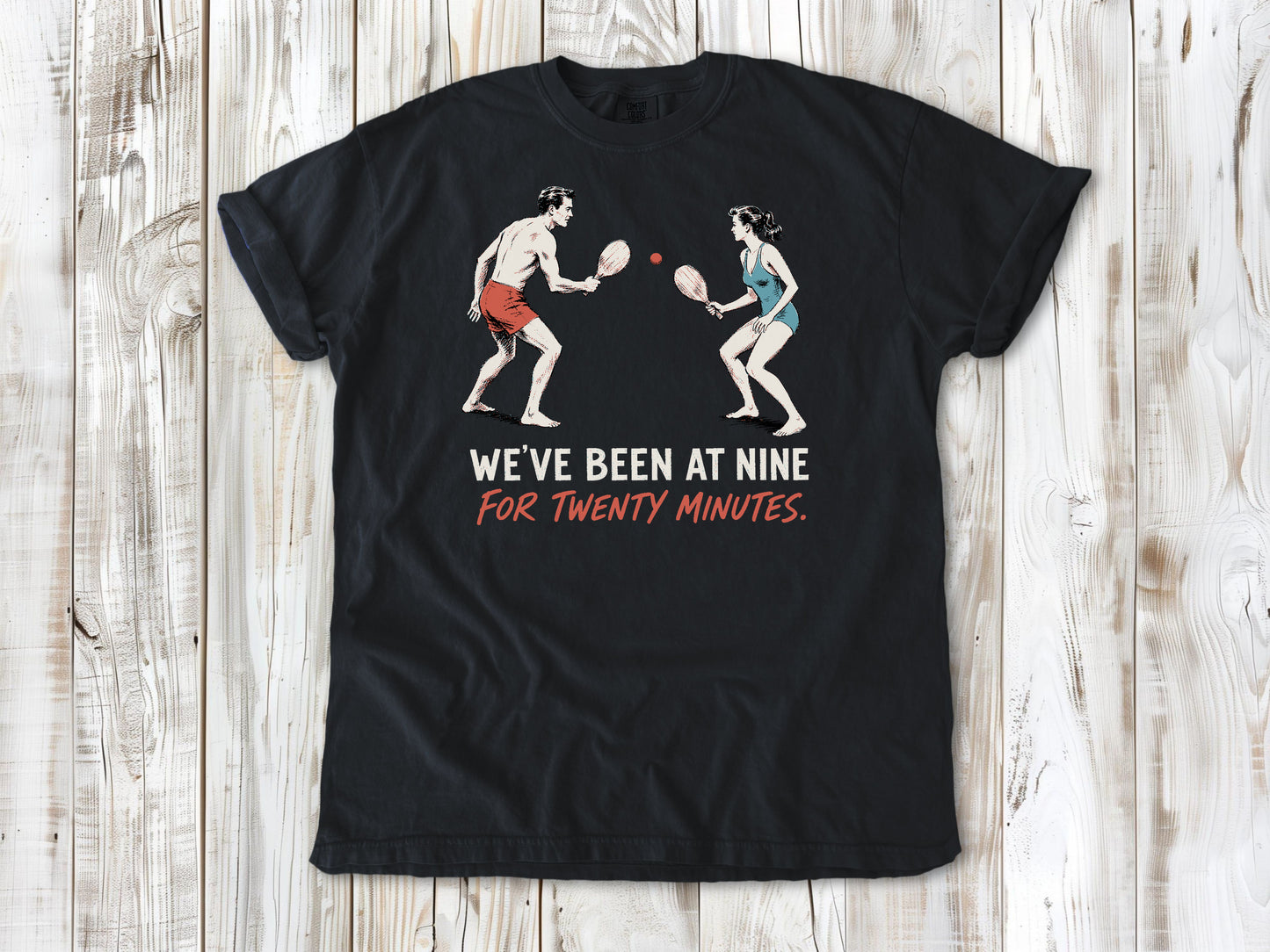 Washed Denim garment-dyed tee with We've Been at Nine for Twenty Minutes beach paddleball graphic.