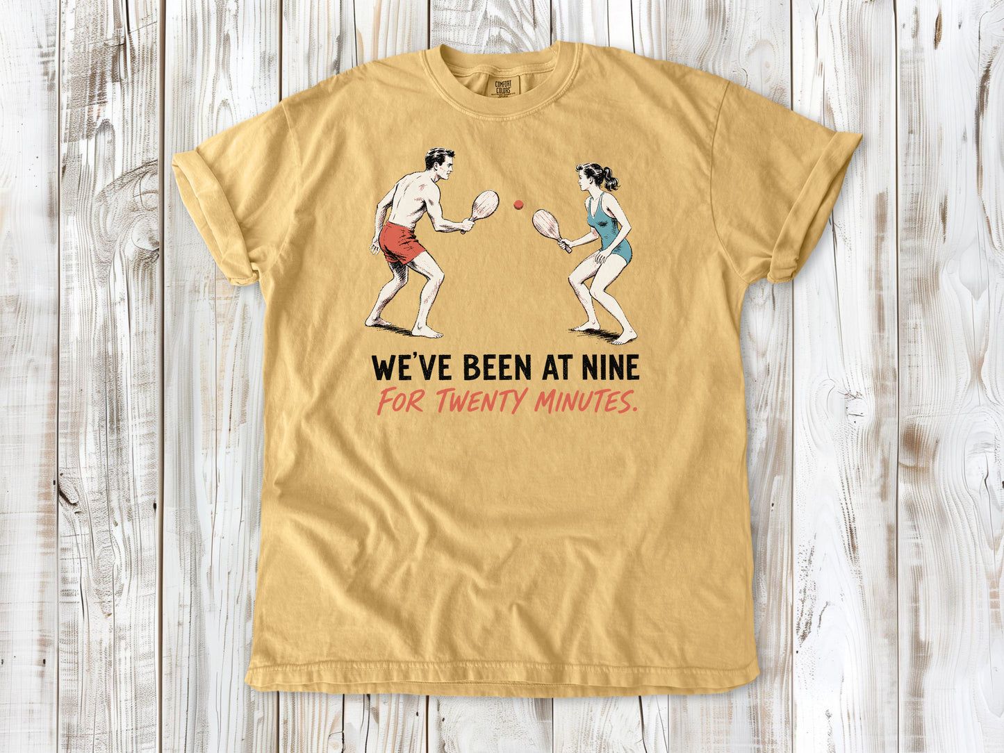 Burnt Orange garment-dyed tee with We've Been at Nine for Twenty Minutes beach paddleball graphic.