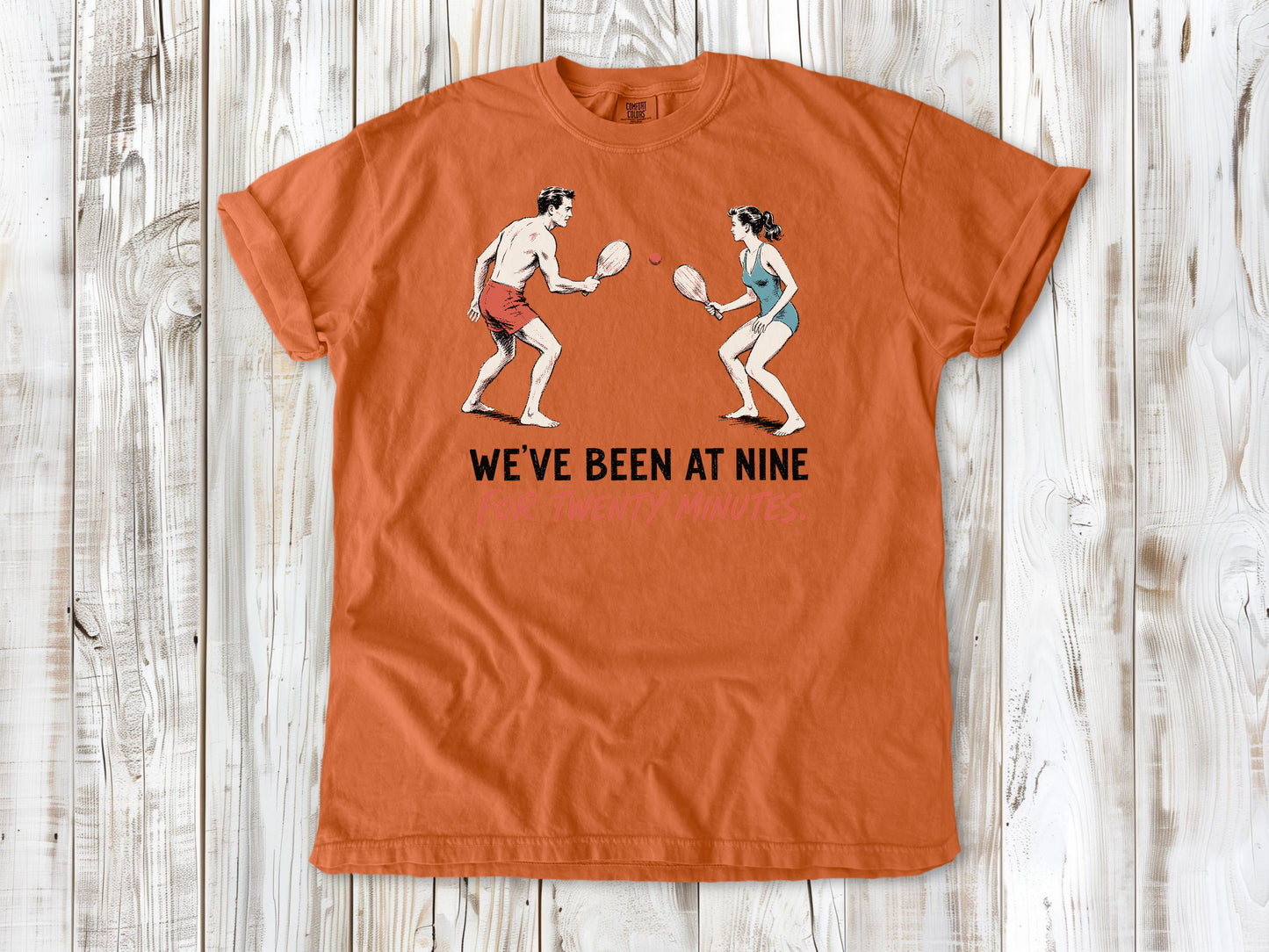 Seafoam garment-dyed tee with We've Been at Nine for Twenty Minutes beach paddleball graphic.