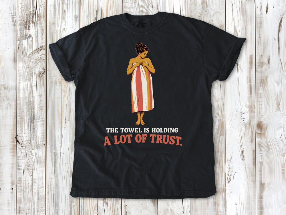 Washed Denim garment-dyed tee with The Towel Is Holding a Lot of Trust beach graphic.