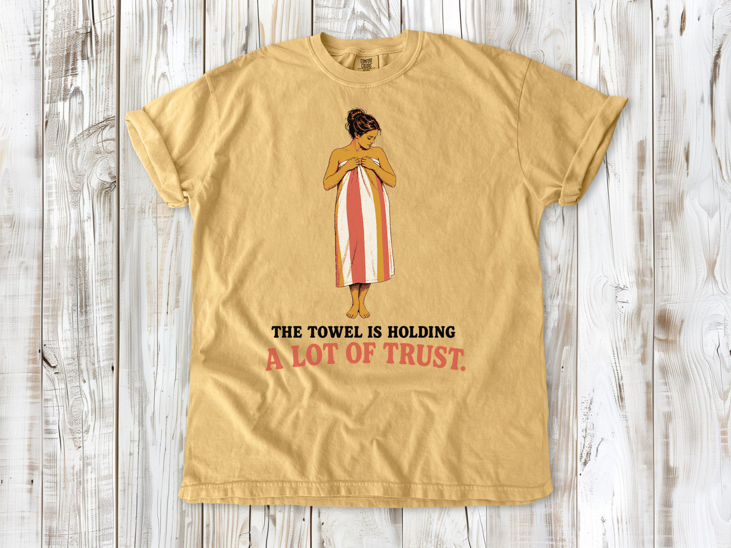 Burnt Orange garment-dyed tee with The Towel Is Holding a Lot of Trust beach graphic.