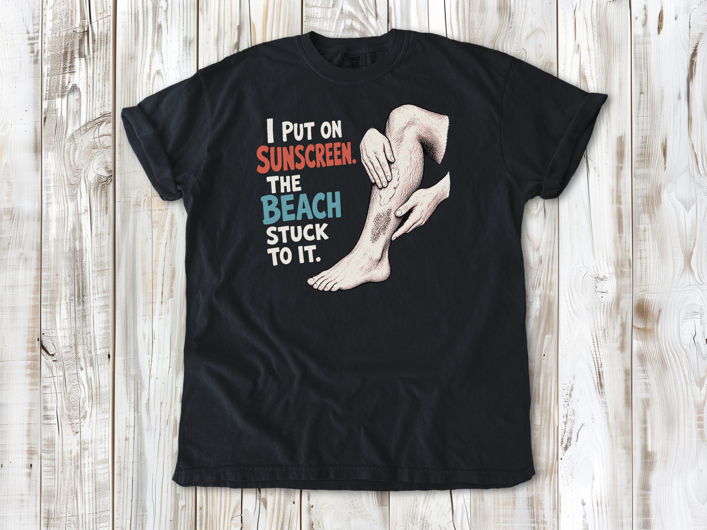 Washed Denim garment-dyed tee with I Put on Sunscreen The Beach Stuck to It graphic.