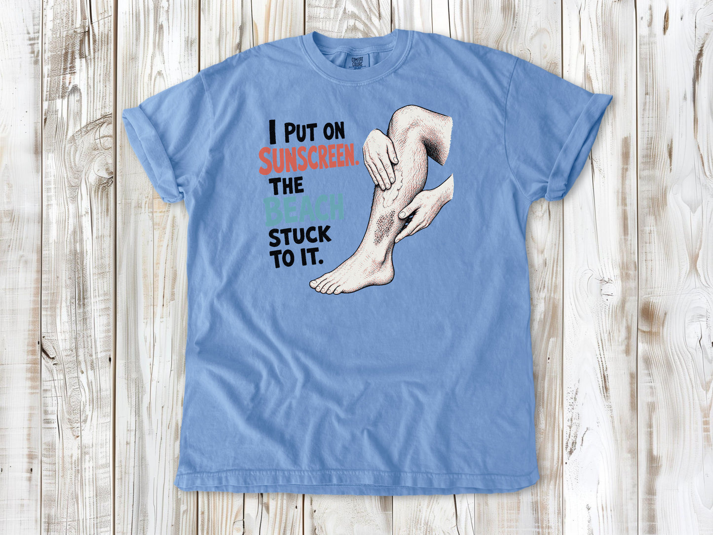 Pepper garment-dyed tee with I Put on Sunscreen The Beach Stuck to It graphic.