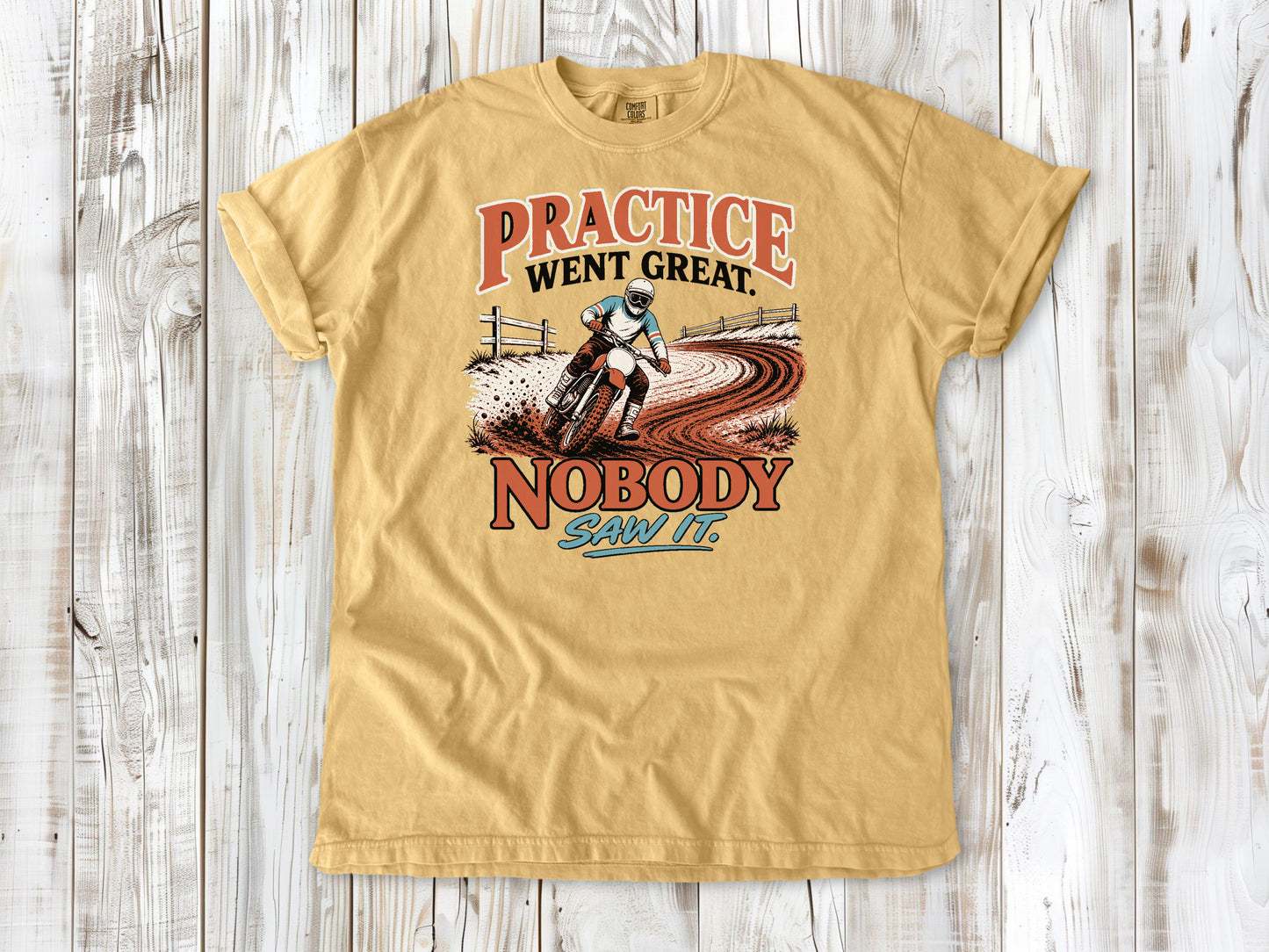 Mustard garment-dyed tee with Practice Went Great Nobody Saw It motocross graphic.