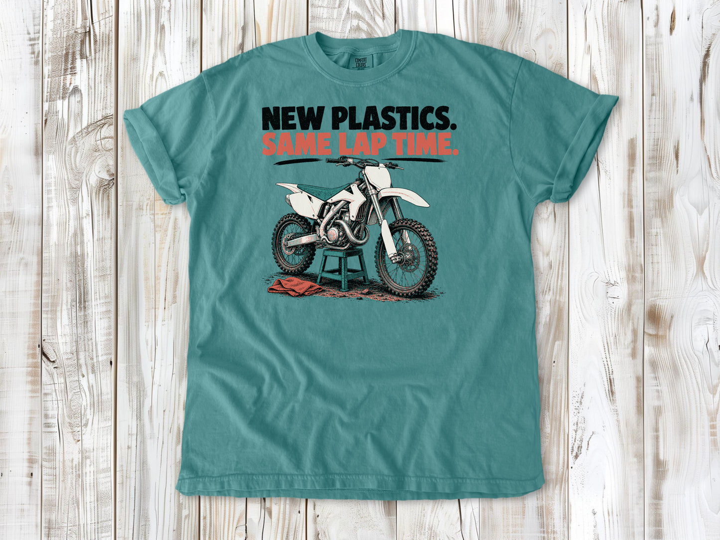 Seafoam garment-dyed tee with New Plastics Same Lap Time dirt bike graphic.
