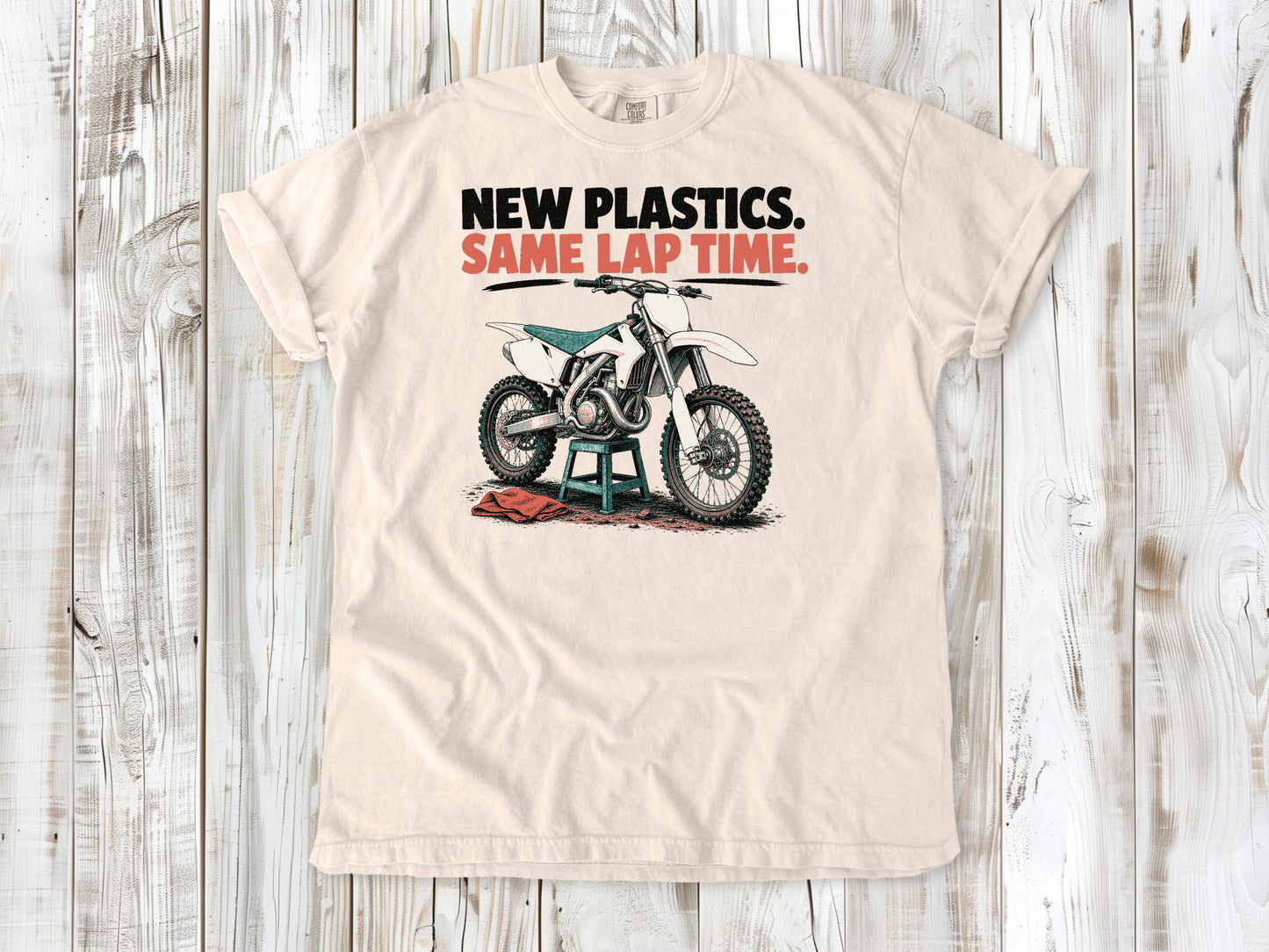 Ivory garment-dyed tee with New Plastics Same Lap Time dirt bike graphic.