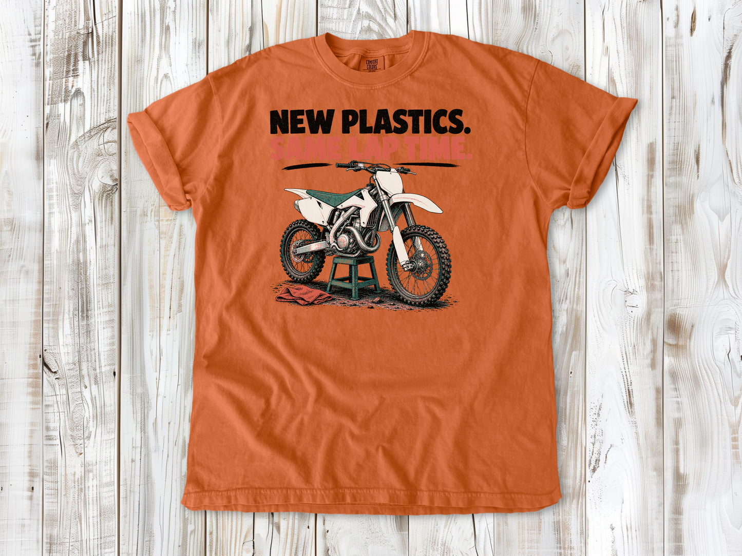 Burnt Orange garment-dyed tee with New Plastics Same Lap Time dirt bike graphic.