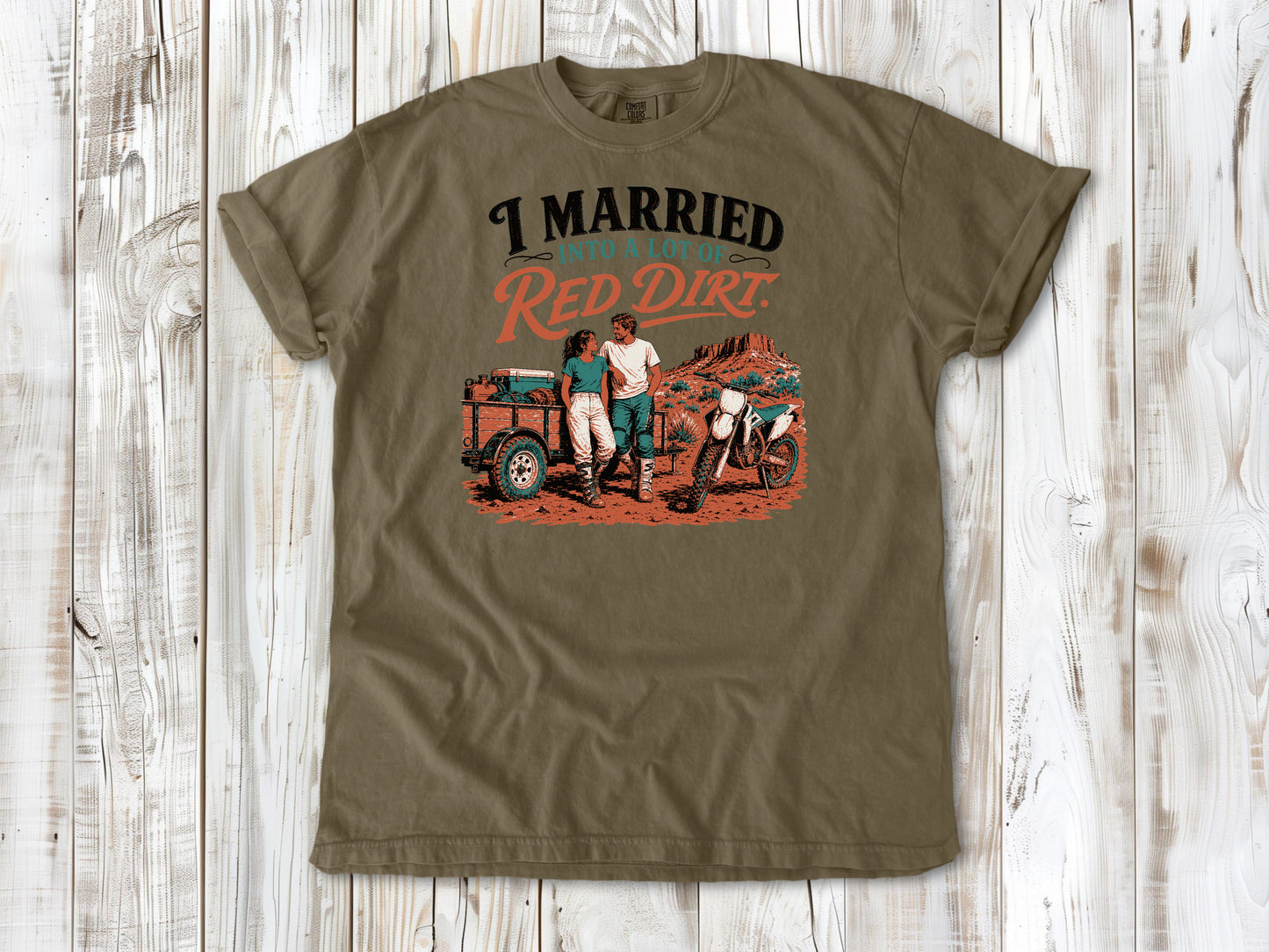 Khaki garment-dyed tee with I Married Into a Lot of Red Dirt motocross couple graphic.