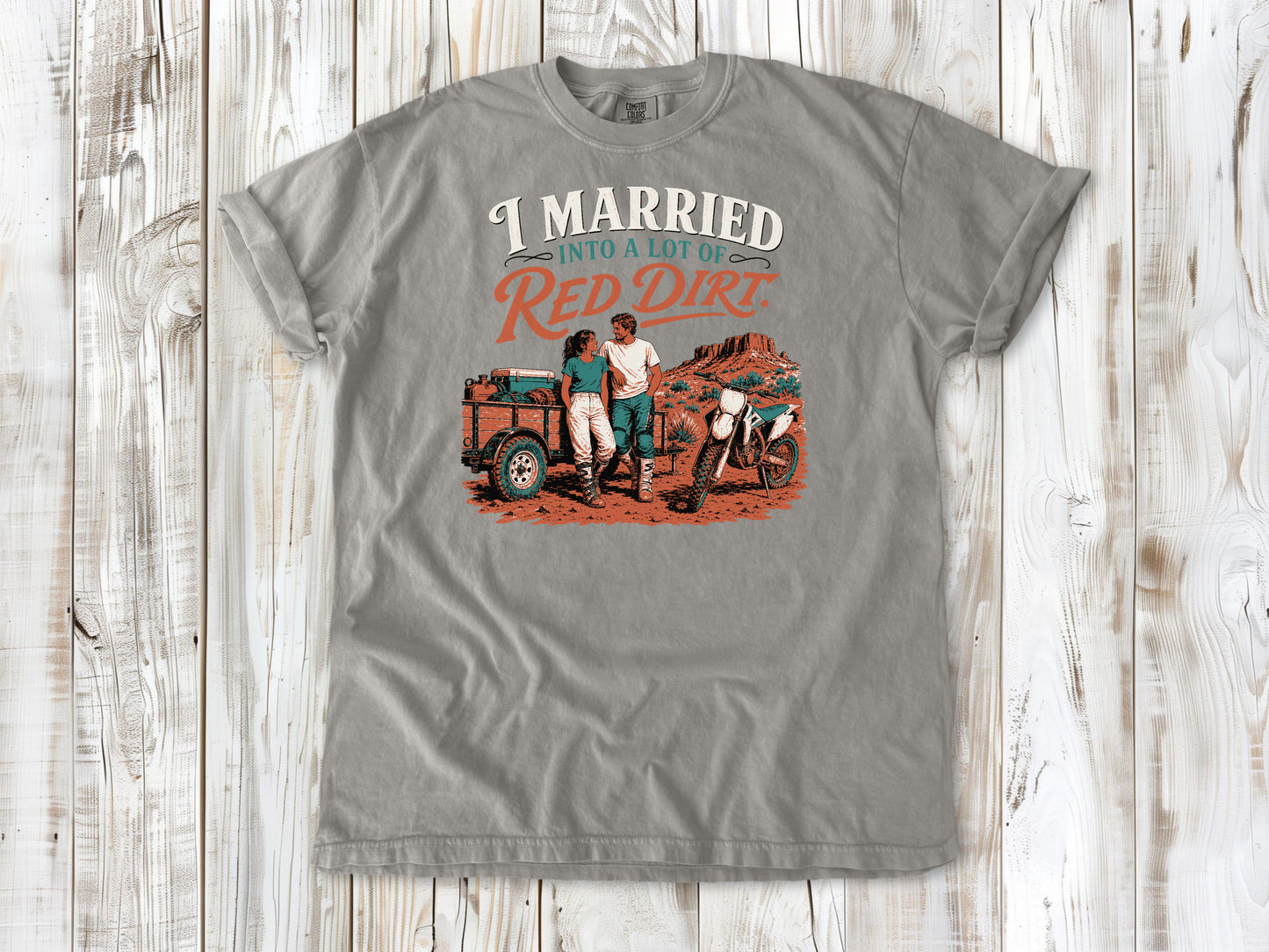 Grey garment-dyed tee with I Married Into a Lot of Red Dirt motocross couple graphic.