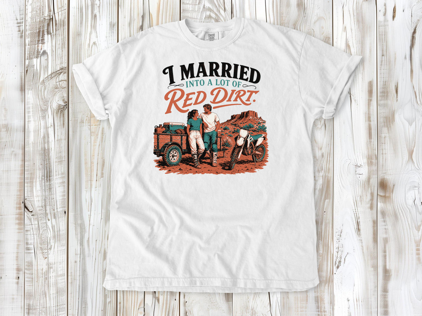 White garment-dyed tee with I Married Into a Lot of Red Dirt motocross couple graphic.