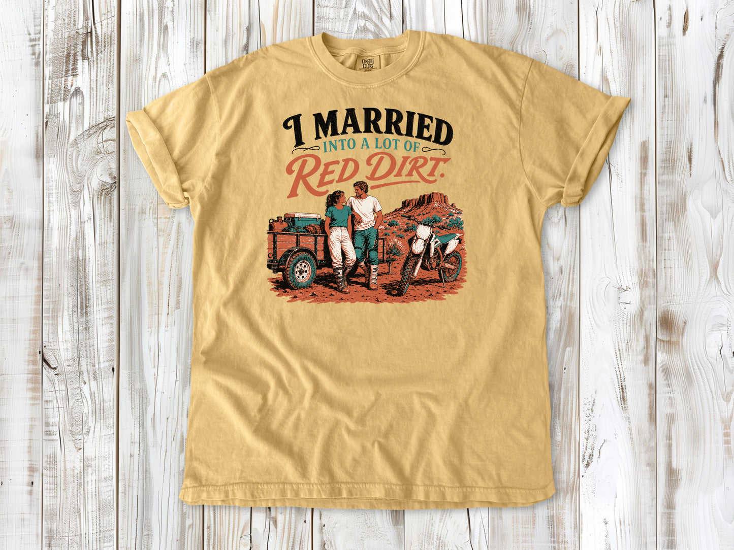 Mustard garment-dyed tee with I Married Into a Lot of Red Dirt motocross couple graphic.