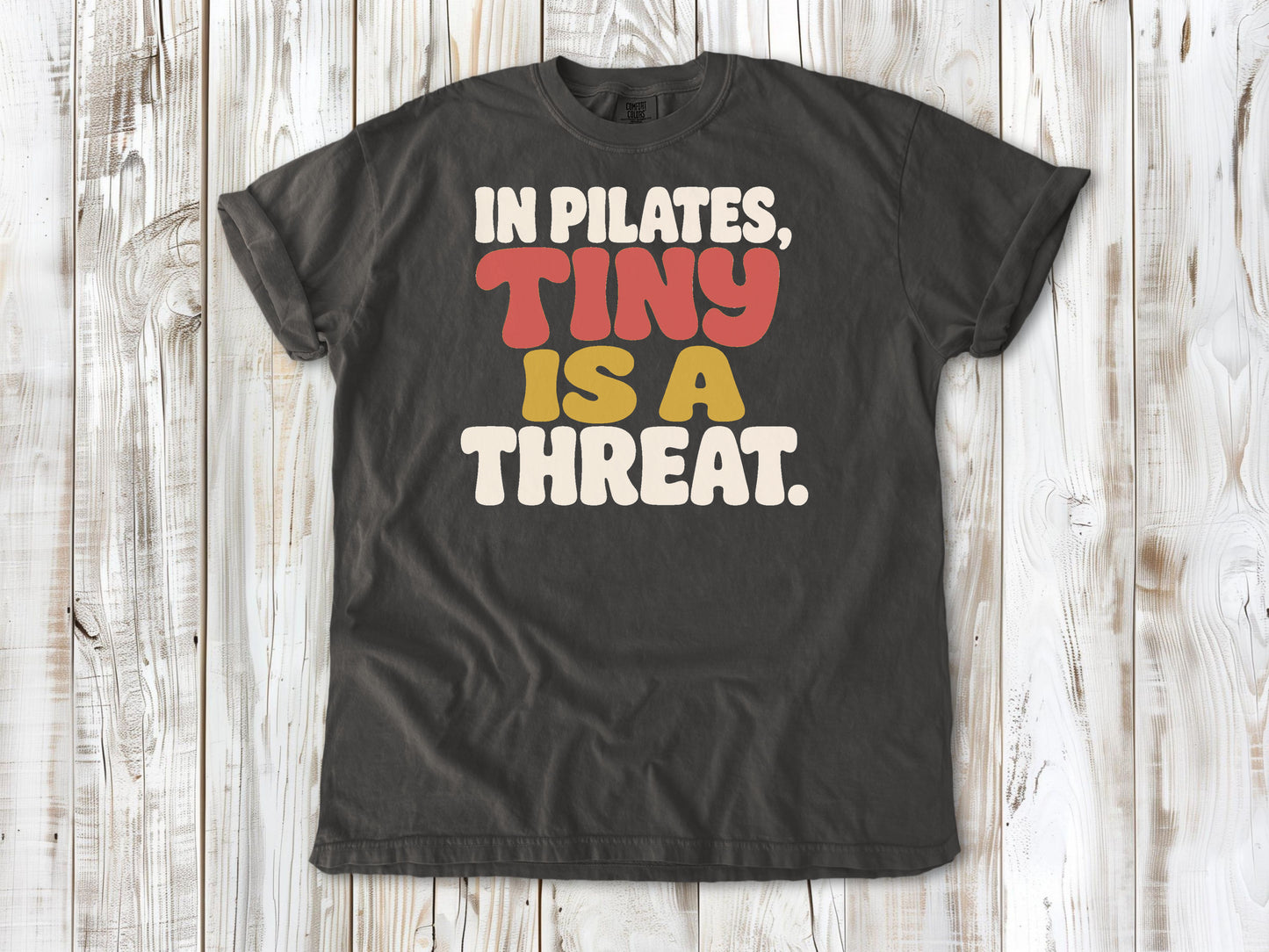 Pepper garment-dyed tee with In Pilates Tiny Is a Threat studio humor graphic.