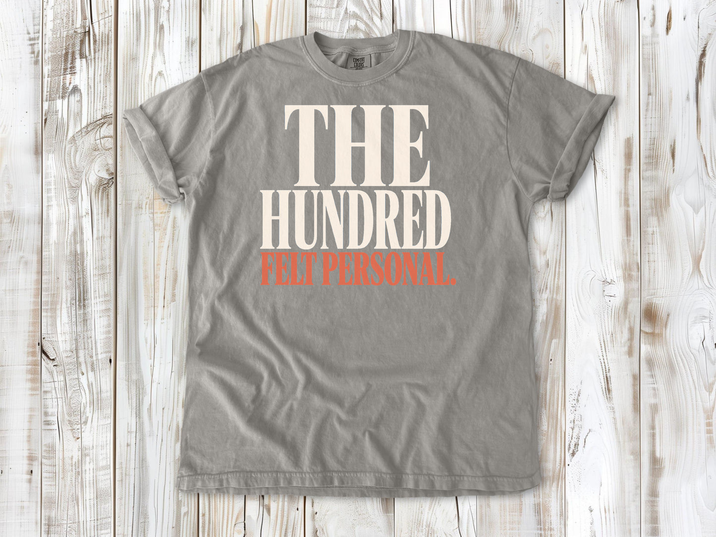 Grey garment-dyed tee with The Hundred Felt Personal Pilates exercise graphic.