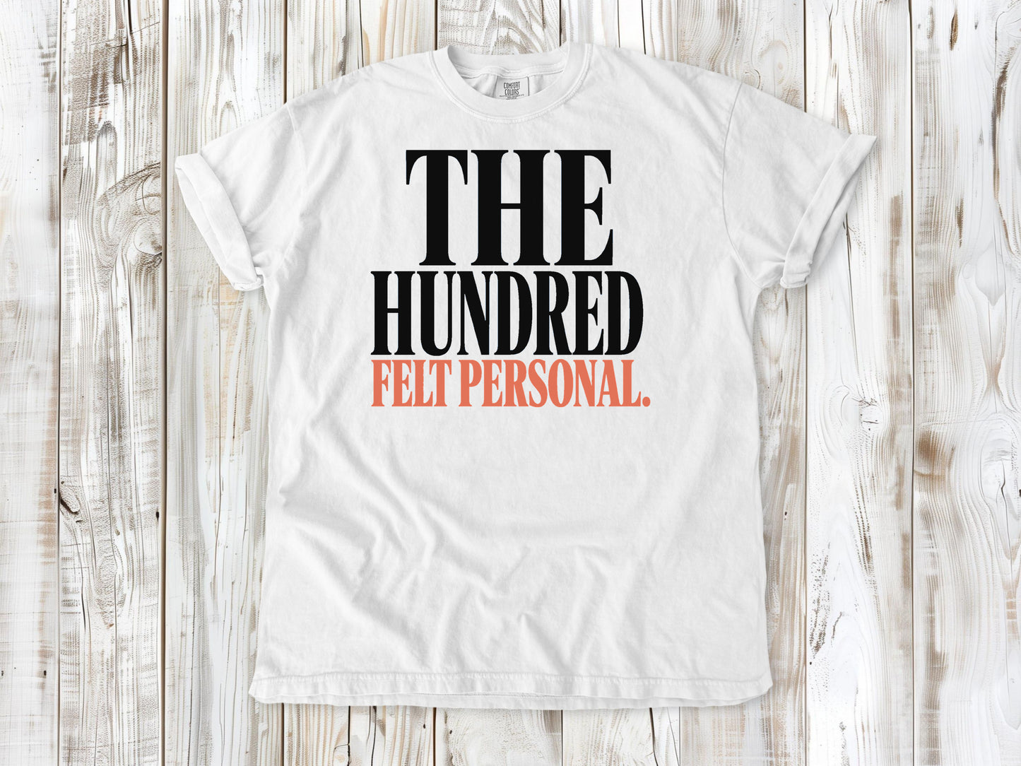 White garment-dyed tee with The Hundred Felt Personal Pilates exercise graphic.