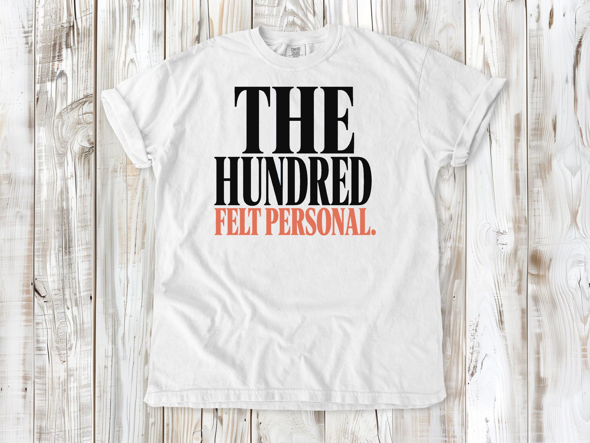 White garment-dyed tee with The Hundred Felt Personal Pilates exercise graphic.