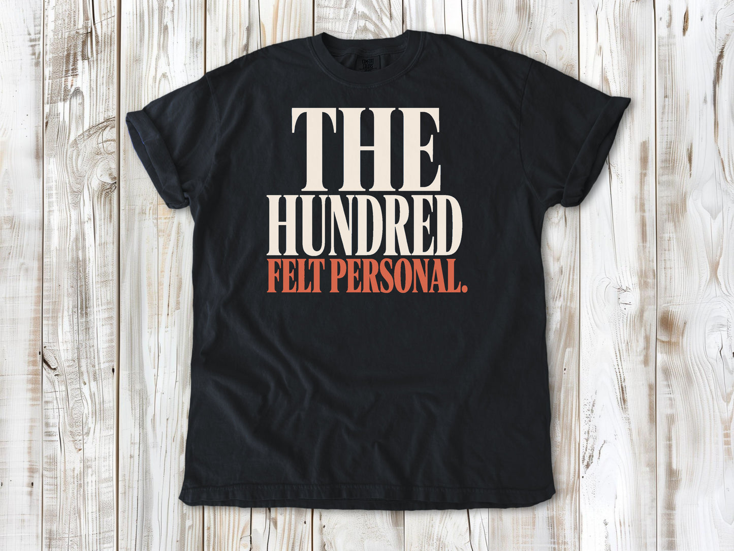 Graphite garment-dyed tee with The Hundred Felt Personal Pilates exercise graphic.