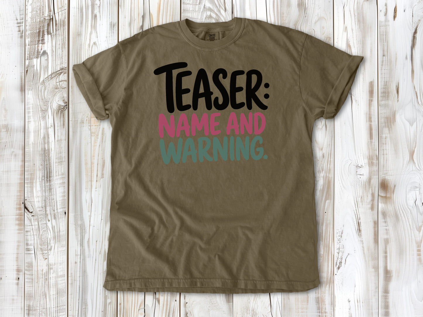 Khaki garment-dyed tee with Teaser Name and Warning Pilates exercise graphic.