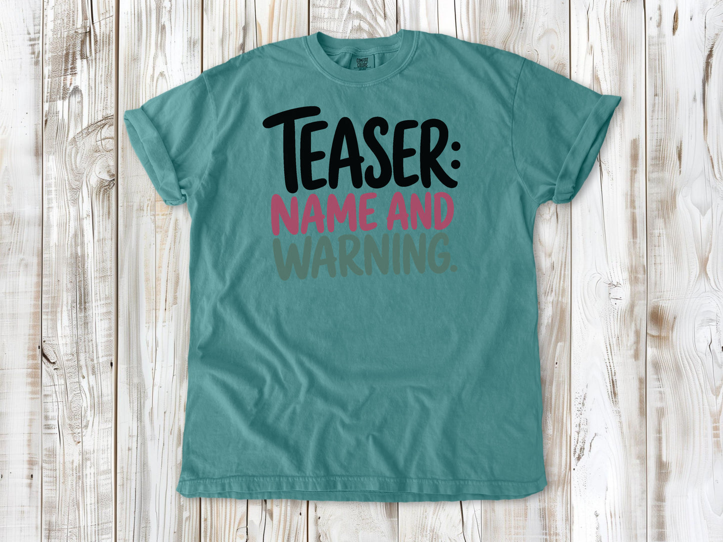 Seafoam garment-dyed tee with Teaser Name and Warning Pilates exercise graphic.