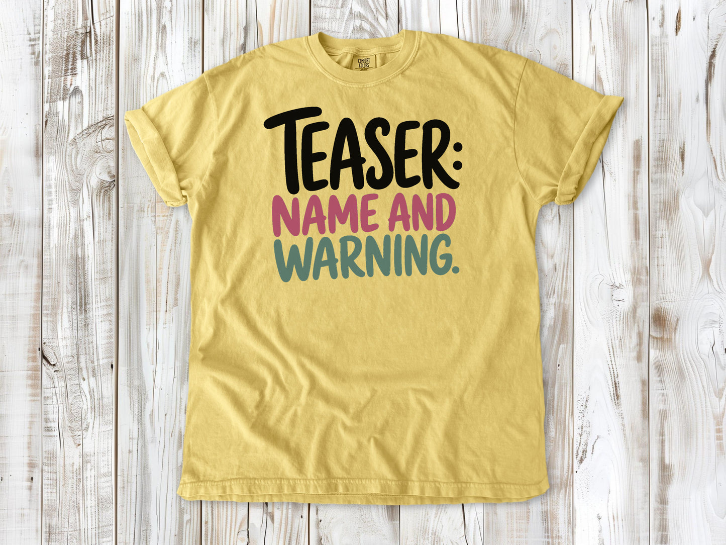 Butter garment-dyed tee with Teaser Name and Warning Pilates exercise graphic.