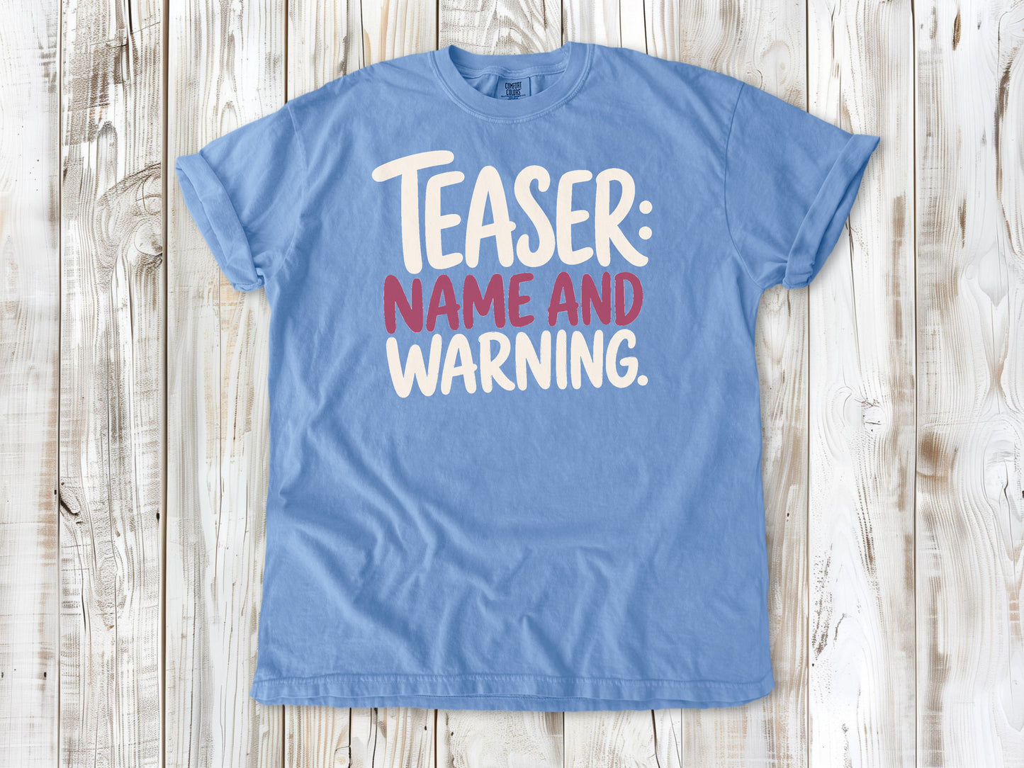 Washed Denim garment-dyed tee with Teaser Name and Warning Pilates exercise graphic.