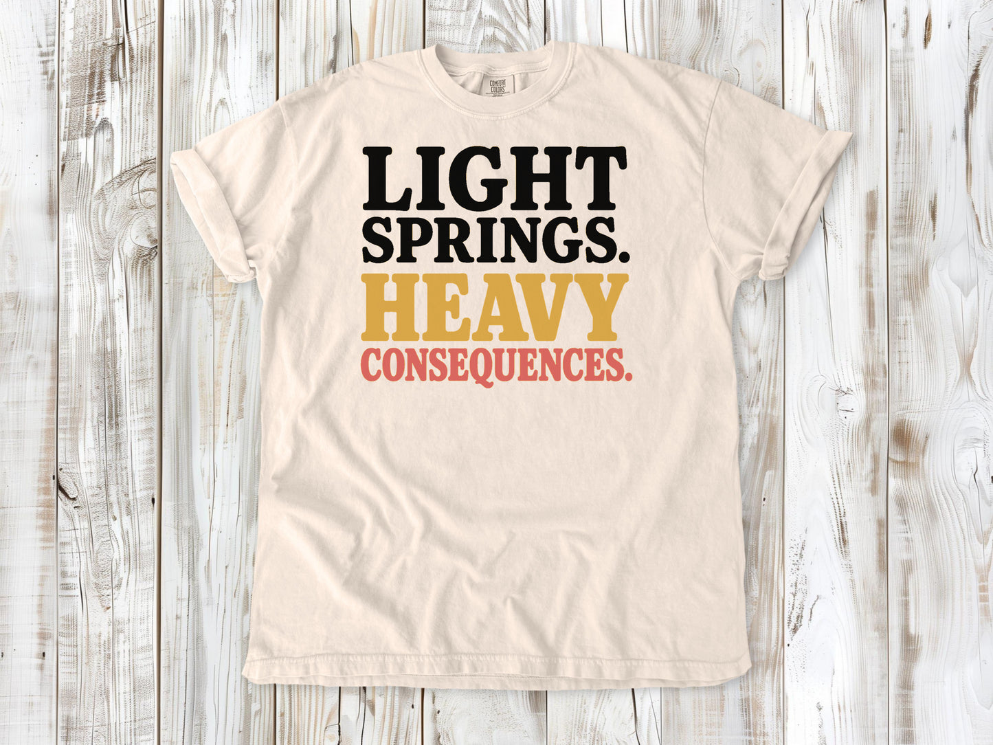 Ivory garment-dyed tee with Light Springs Heavy Consequences reformer Pilates graphic.