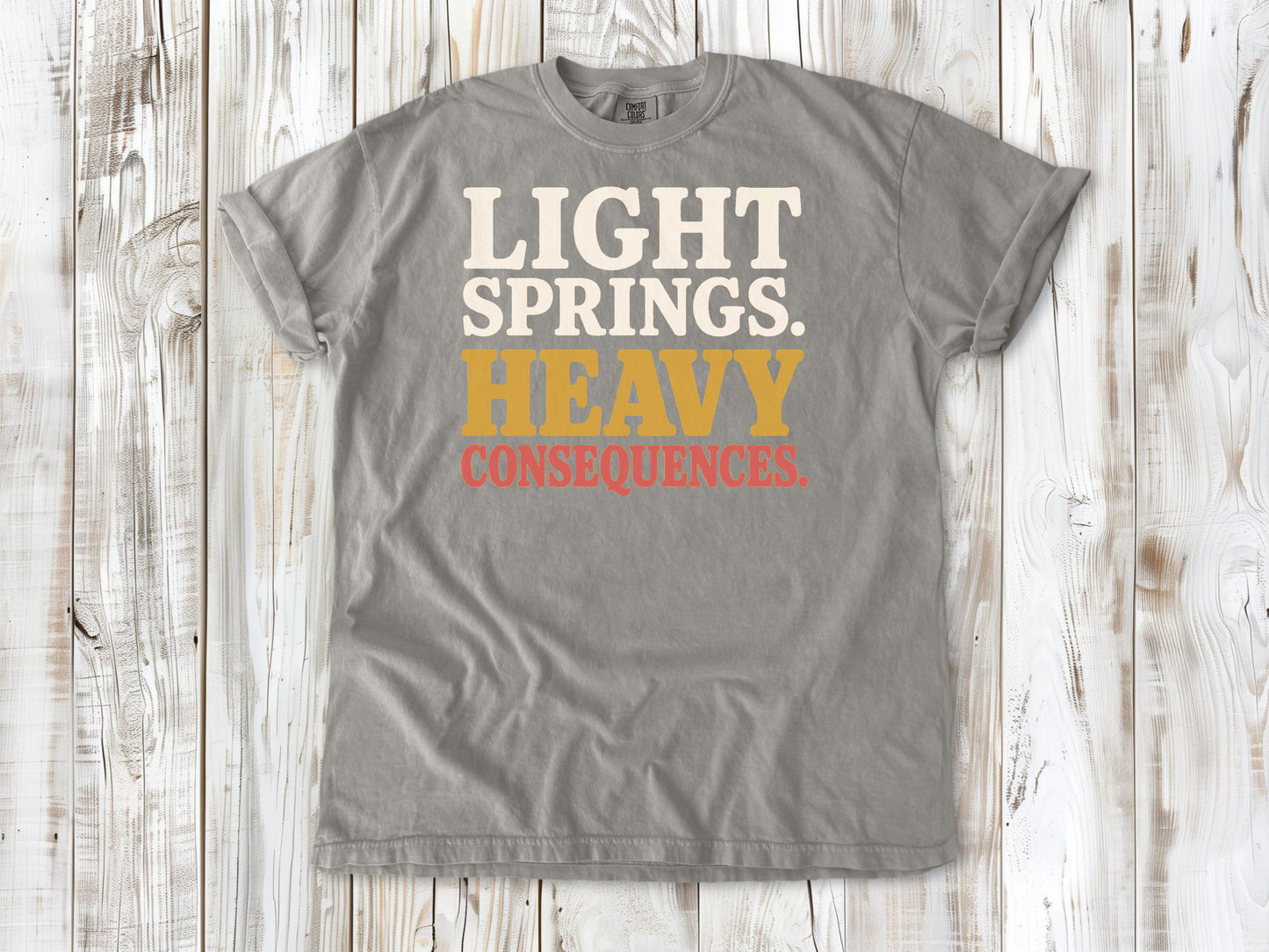 Grey garment-dyed tee with Light Springs Heavy Consequences reformer Pilates graphic.