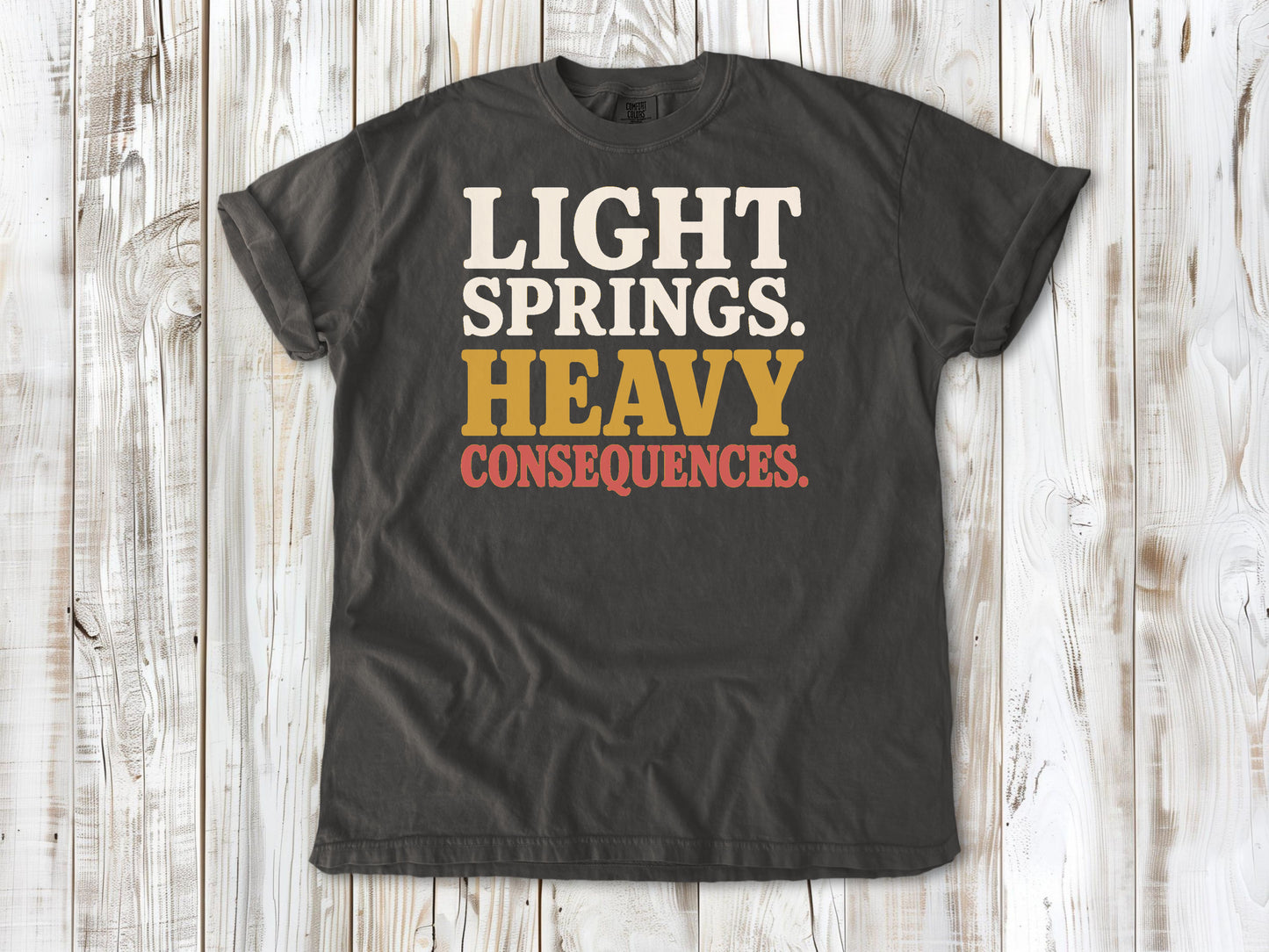 Pepper garment-dyed tee with Light Springs Heavy Consequences reformer Pilates graphic.