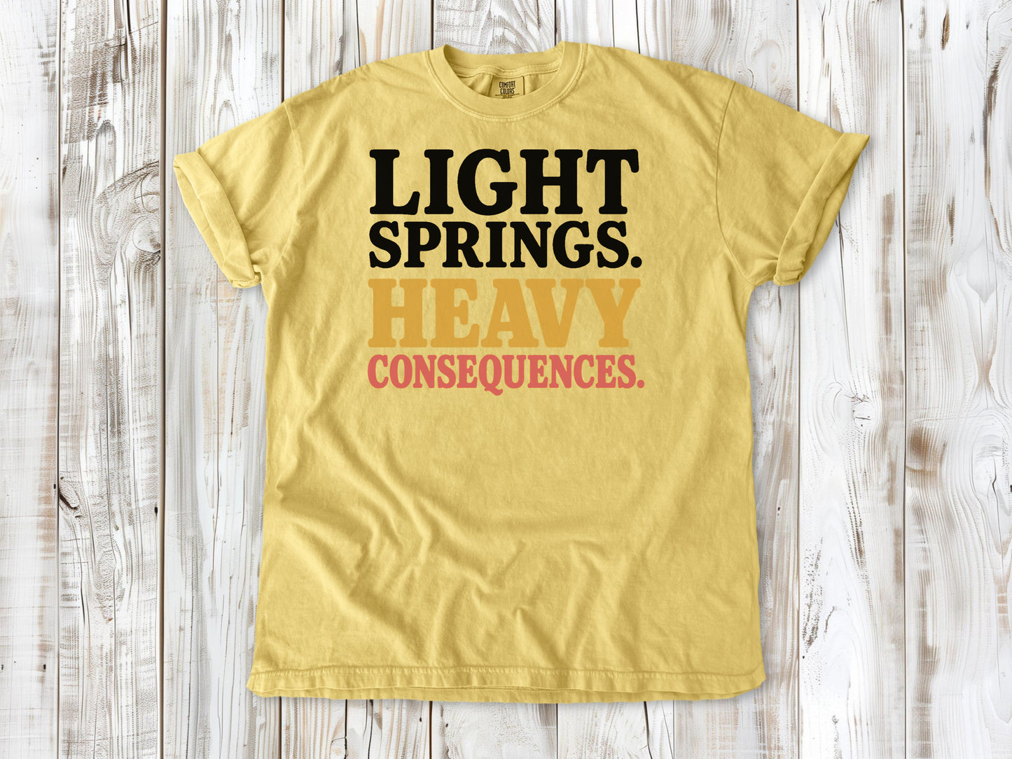 Butter garment-dyed tee with Light Springs Heavy Consequences reformer Pilates graphic.