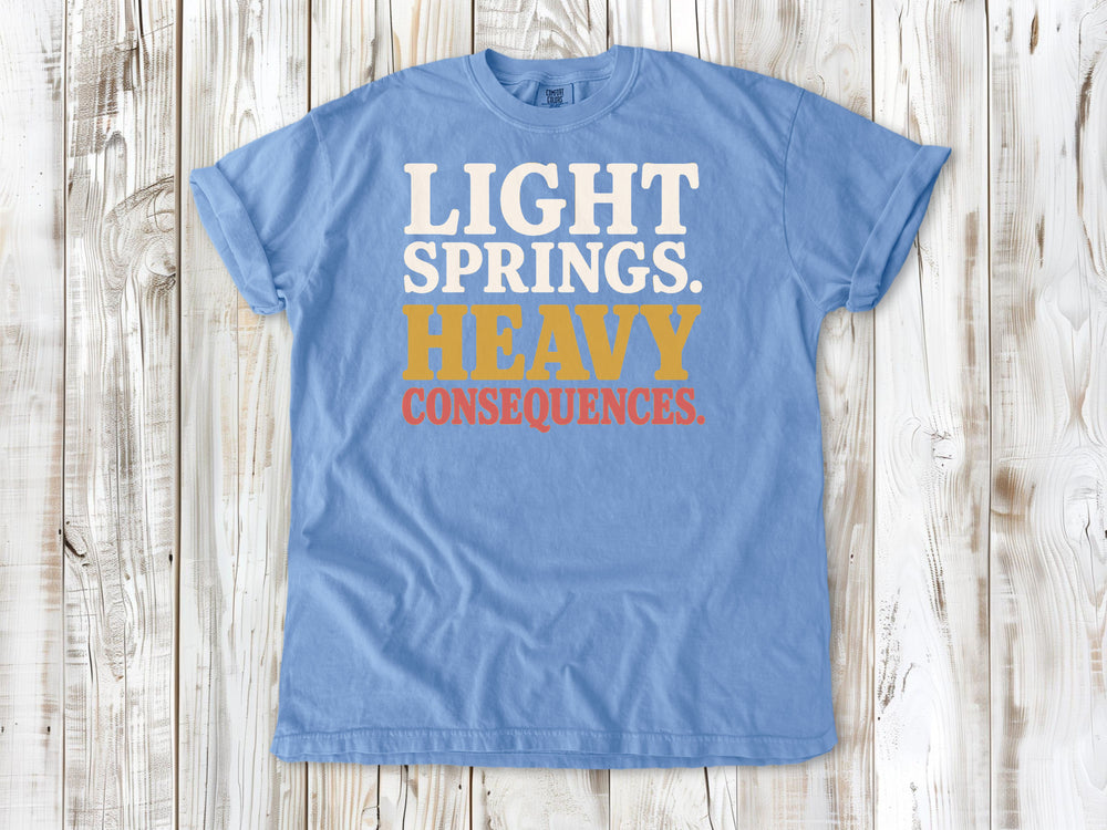 Washed Denim garment-dyed tee with Light Springs Heavy Consequences reformer Pilates graphic.