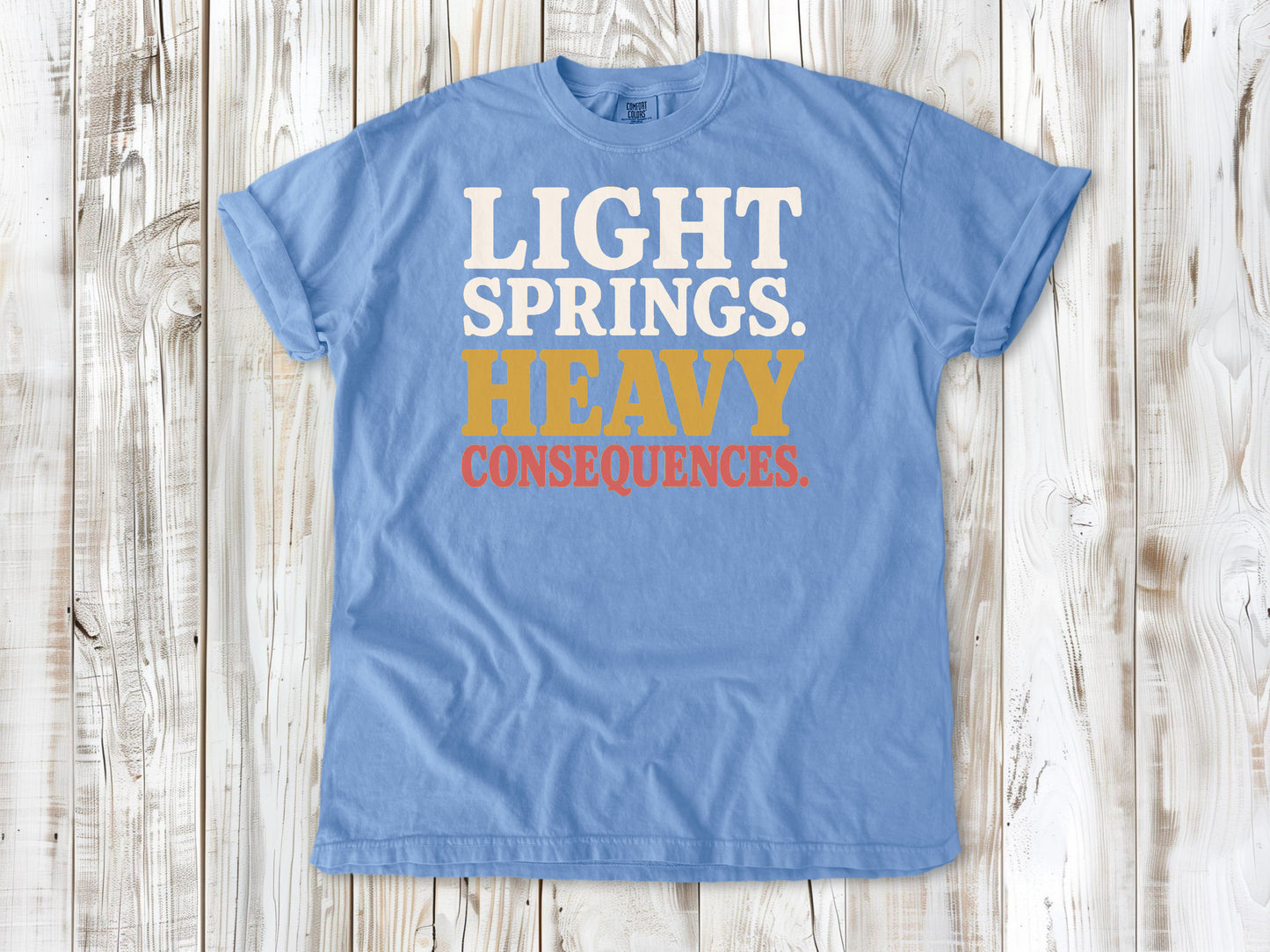 Washed Denim garment-dyed tee with Light Springs Heavy Consequences reformer Pilates graphic.