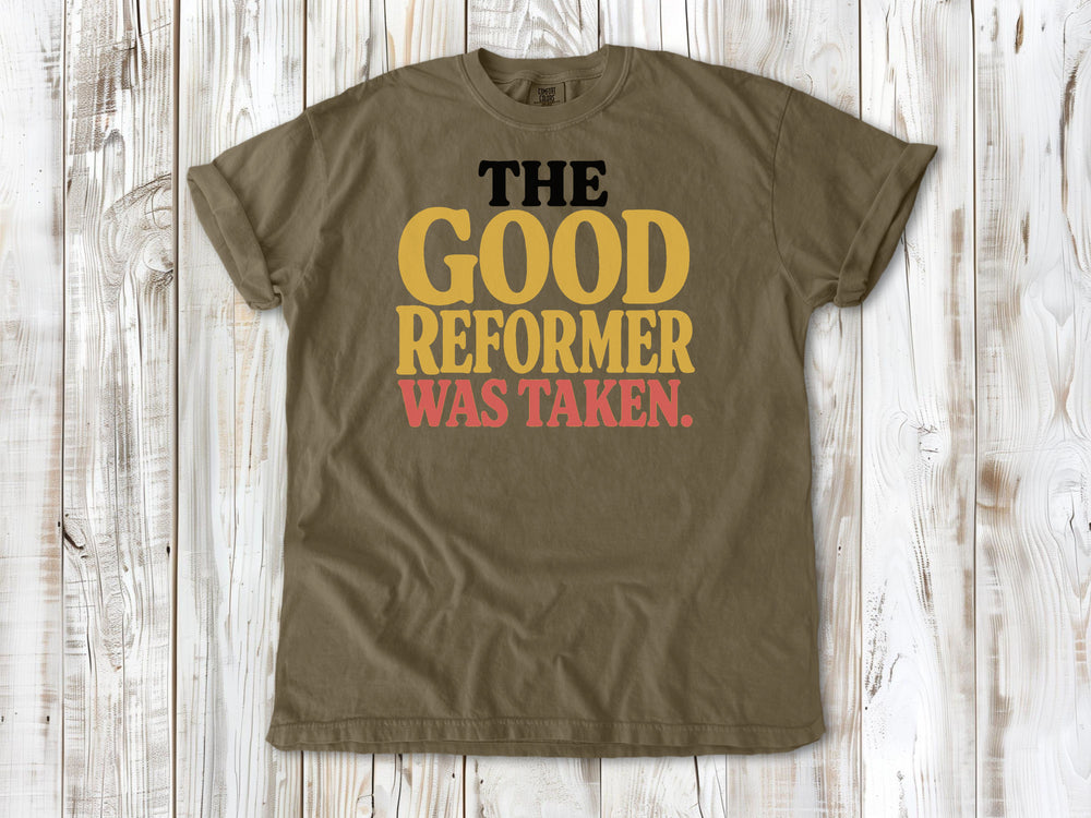 Khaki garment-dyed tee with The Good Reformer Was Taken Pilates studio graphic.