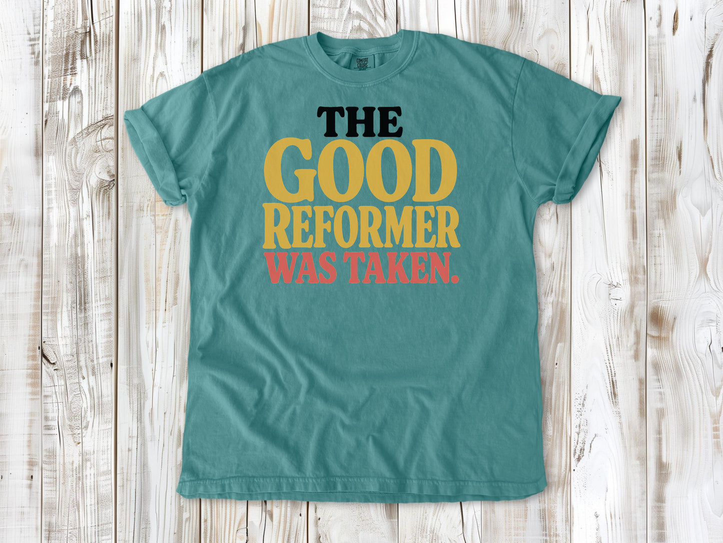 Seafoam garment-dyed tee with The Good Reformer Was Taken Pilates studio graphic.