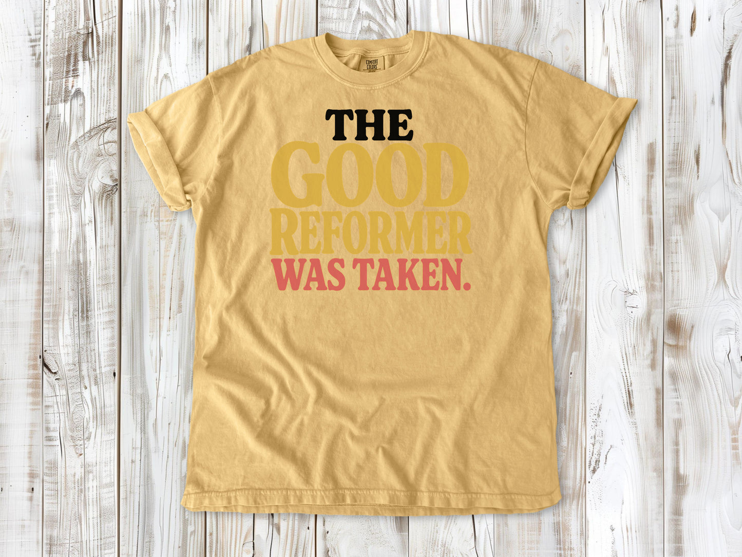 Mustard garment-dyed tee with The Good Reformer Was Taken Pilates studio graphic.