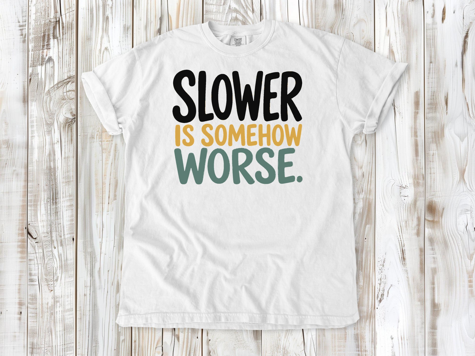 White garment-dyed tee with Slower Is Somehow Worse Pilates workout graphic.
