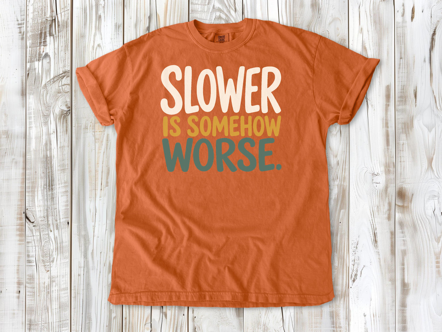 Burnt Orange garment-dyed tee with Slower Is Somehow Worse Pilates workout graphic.