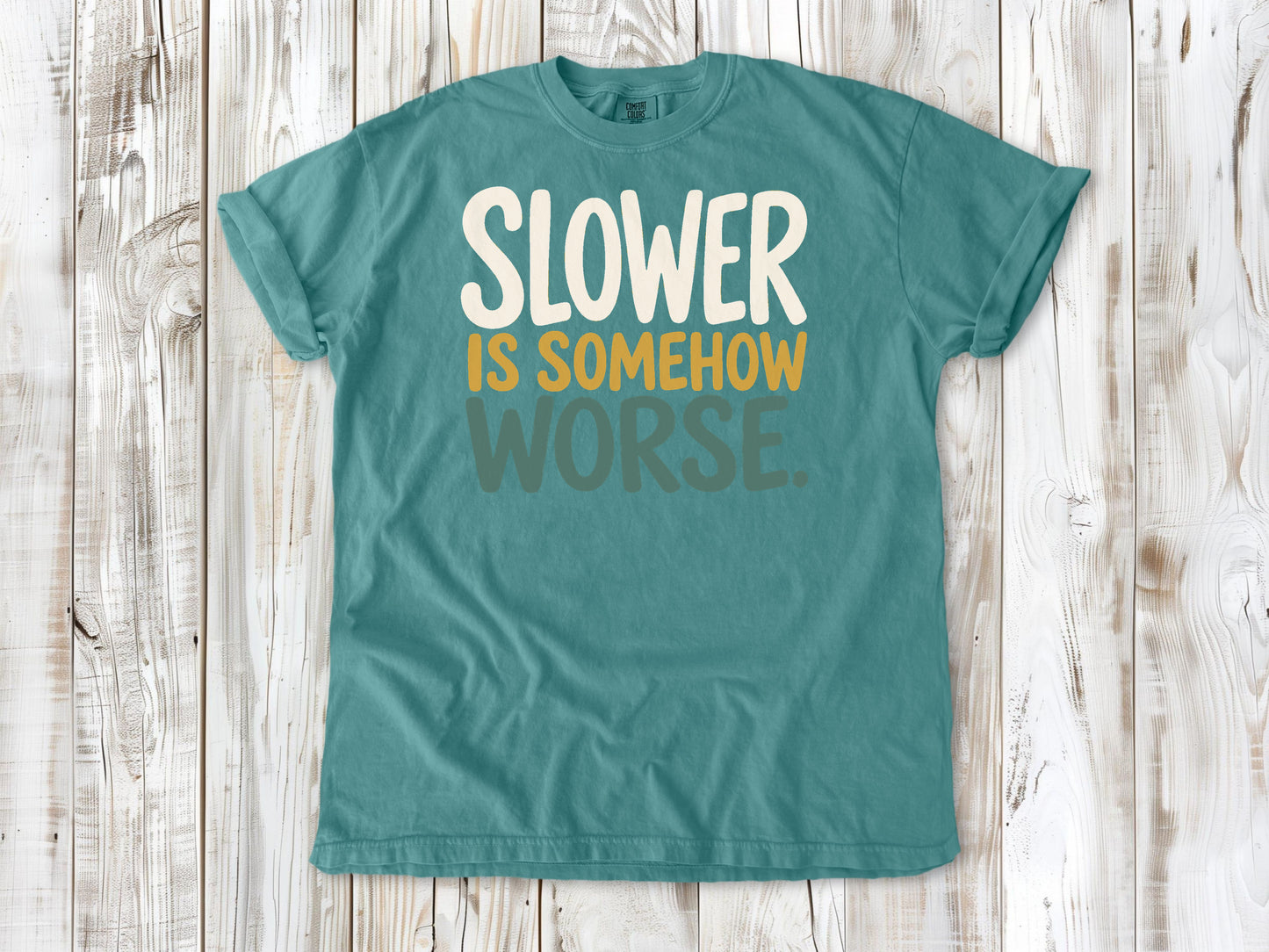 Seafoam garment-dyed tee with Slower Is Somehow Worse Pilates workout graphic.