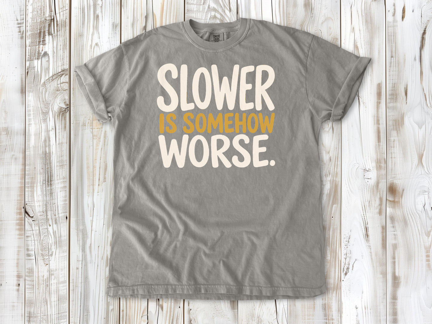 Grey garment-dyed tee with Slower Is Somehow Worse Pilates workout graphic.
