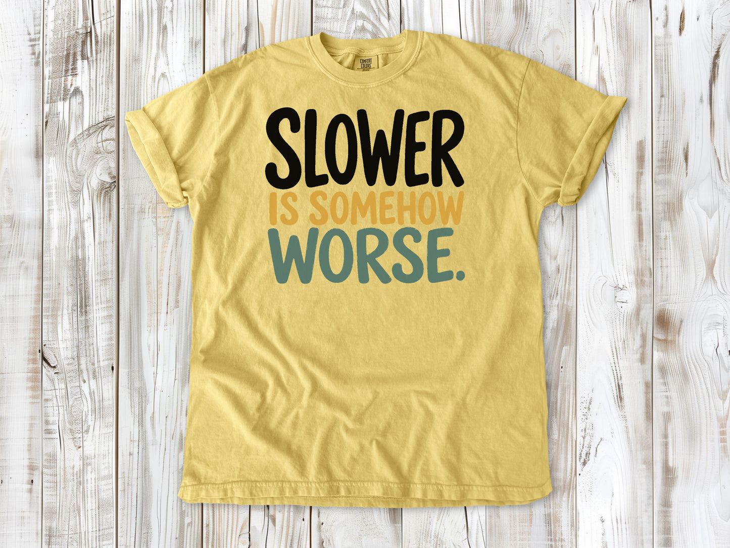 Butter garment-dyed tee with Slower Is Somehow Worse Pilates workout graphic.
