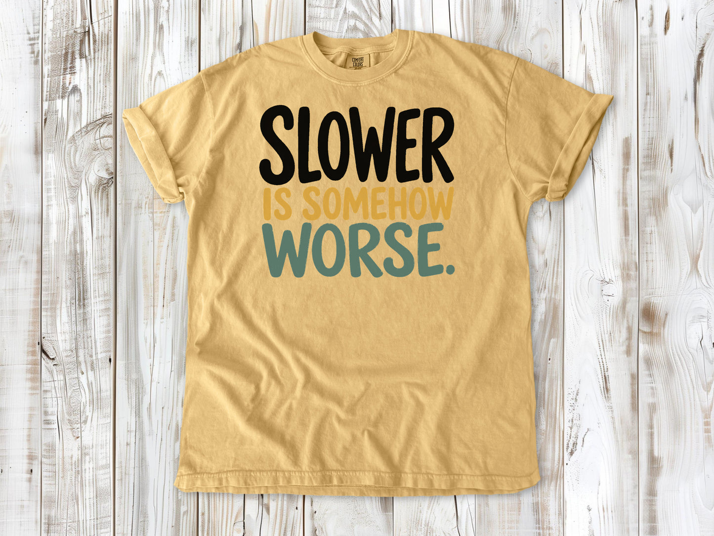 Mustard garment-dyed tee with Slower Is Somehow Worse Pilates workout graphic.