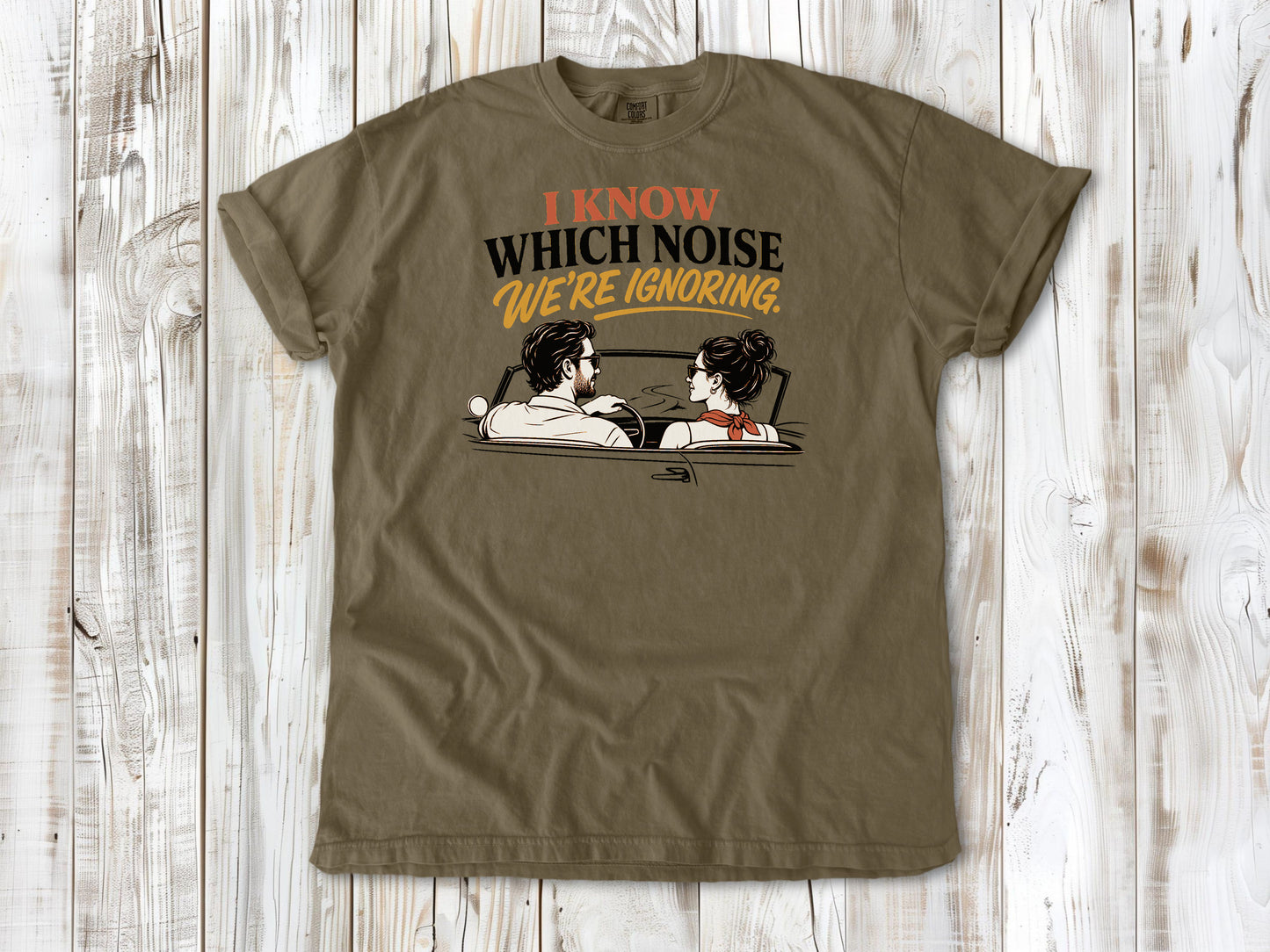 Khaki garment-dyed tee with I Know Which Noise We Are Ignoring car repair graphic.