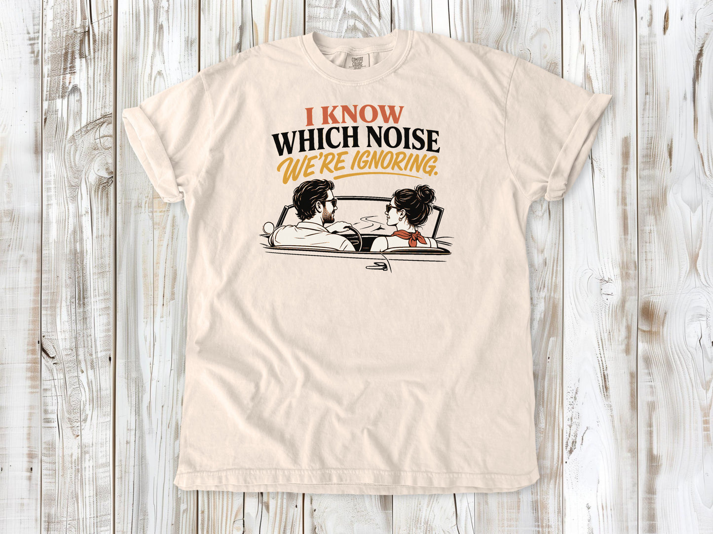 Ivory garment-dyed tee with I Know Which Noise We Are Ignoring car repair graphic.