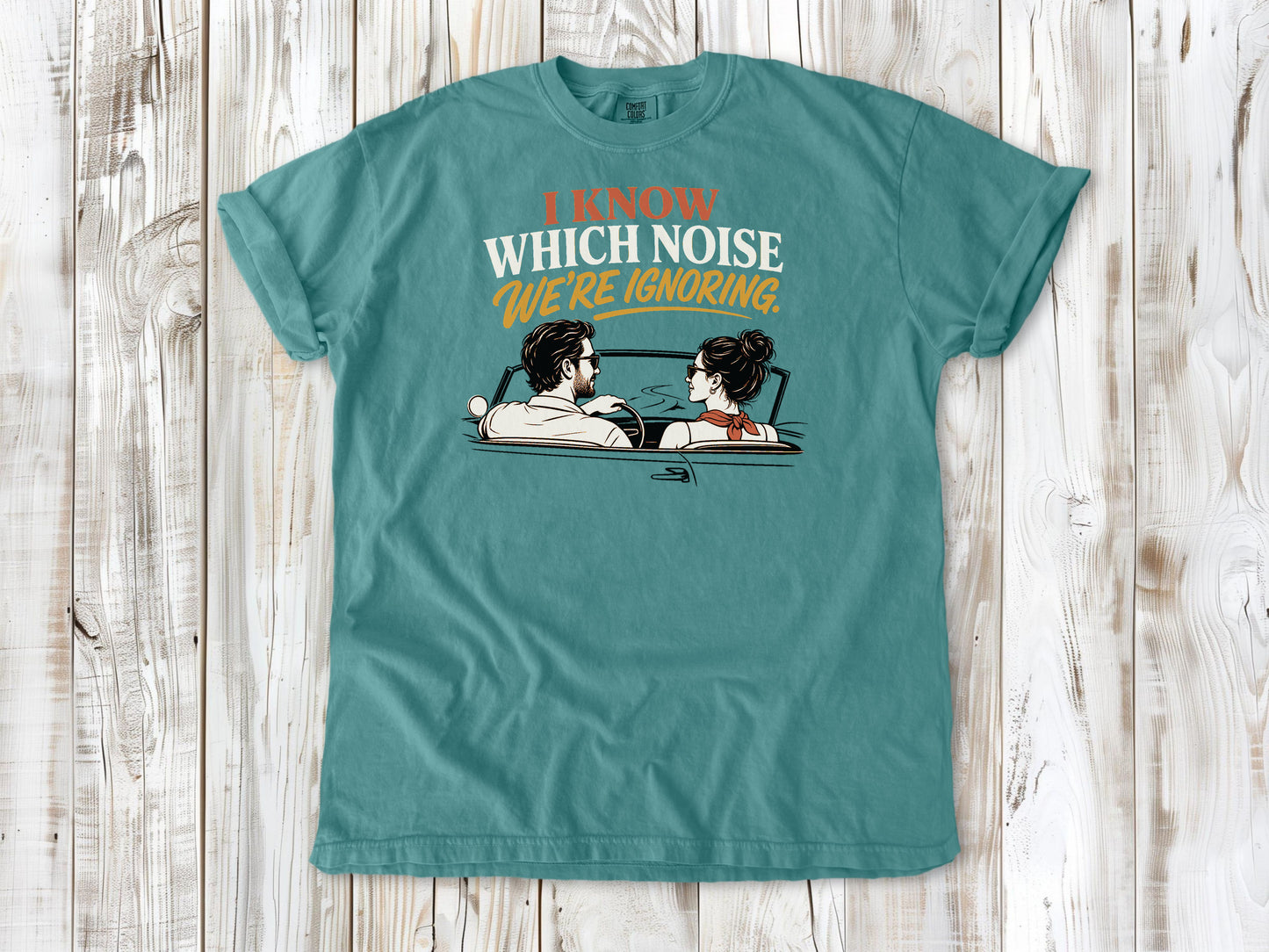 Seafoam garment-dyed tee with I Know Which Noise We Are Ignoring car repair graphic.