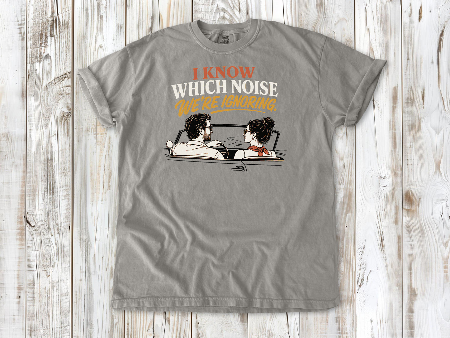 Grey garment-dyed tee with I Know Which Noise We Are Ignoring car repair graphic.