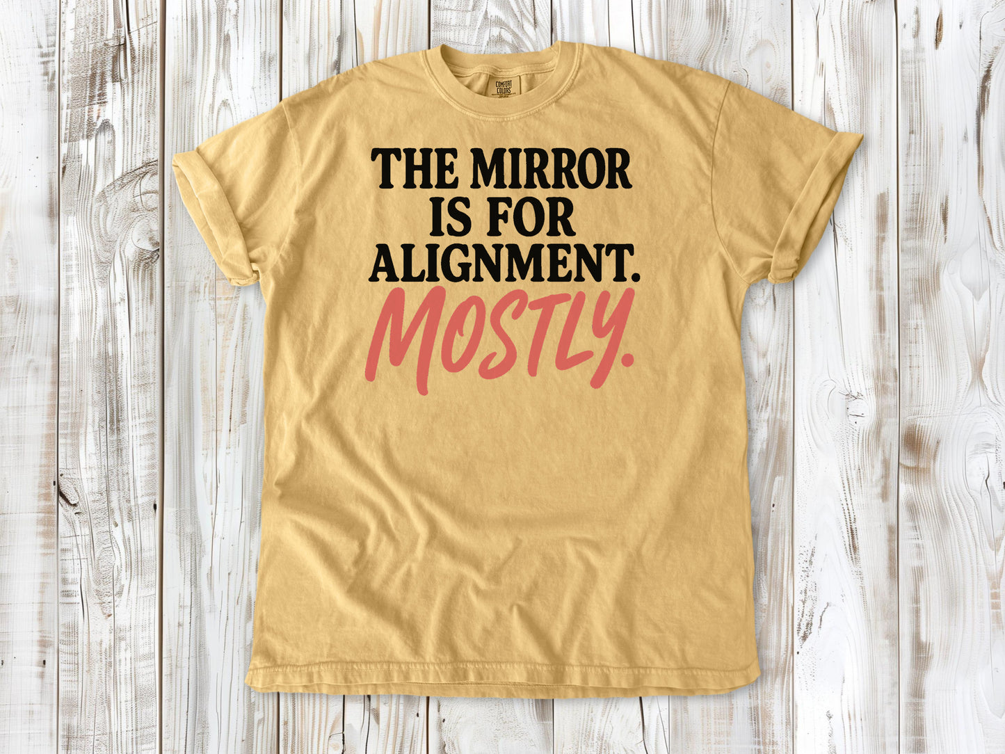 Mustard garment-dyed tee with The Mirror Is for Alignment Mostly Pilates studio graphic.