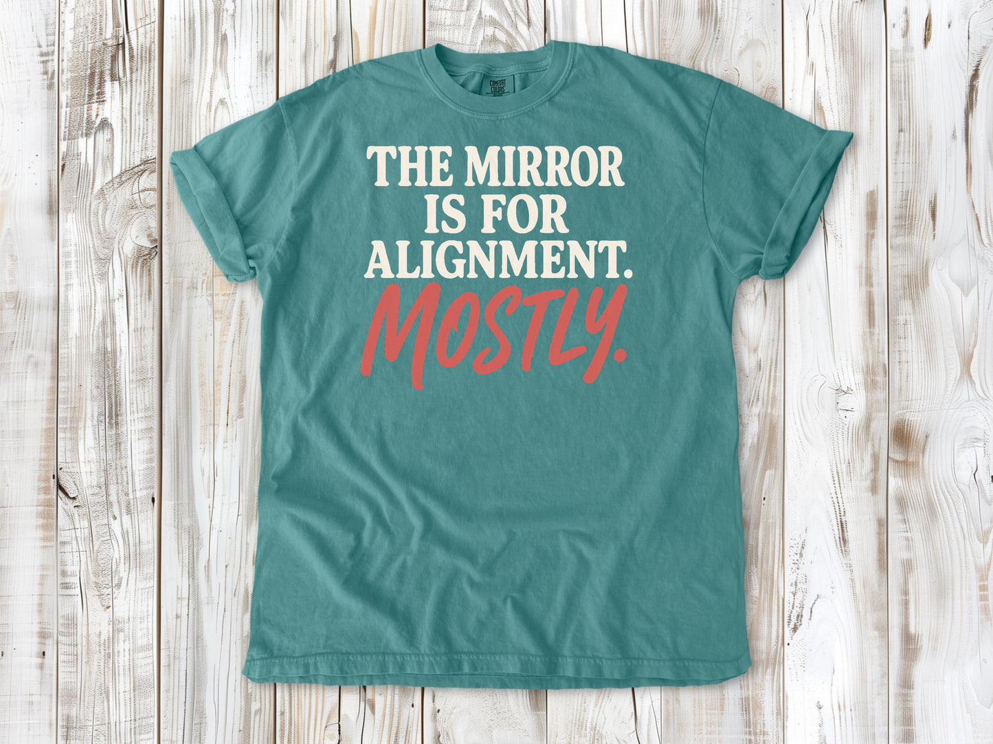 Seafoam garment-dyed tee with The Mirror Is for Alignment Mostly Pilates studio graphic.