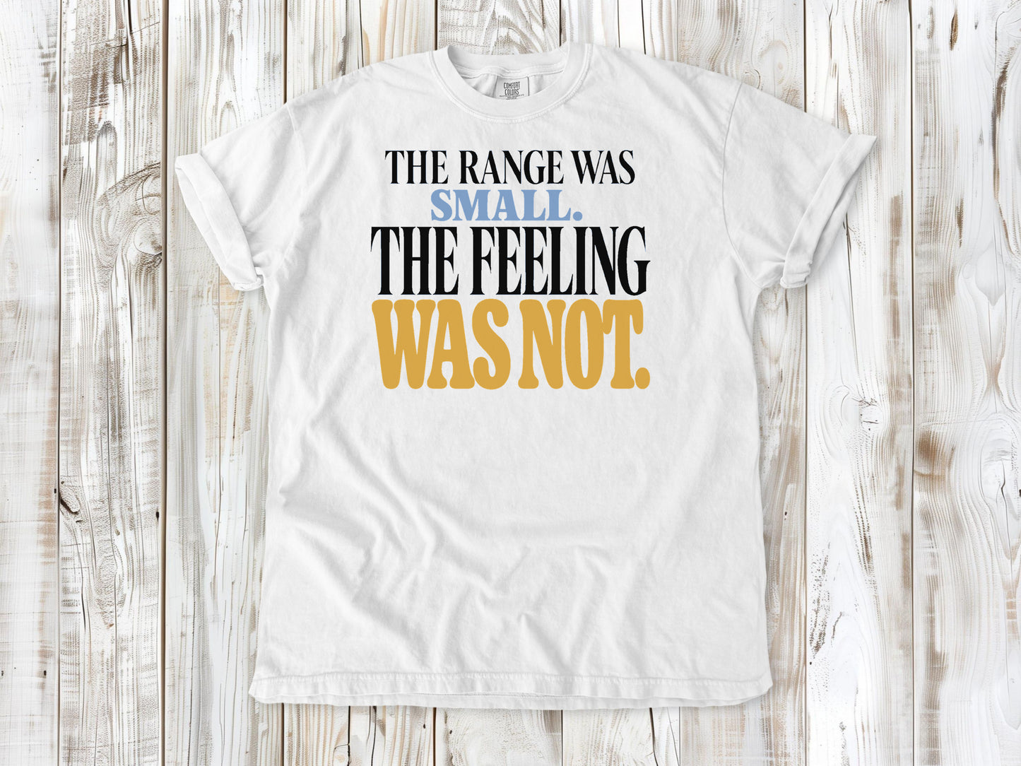 White garment-dyed tee with The Range Was Small The Feeling Was Not Pilates graphic.