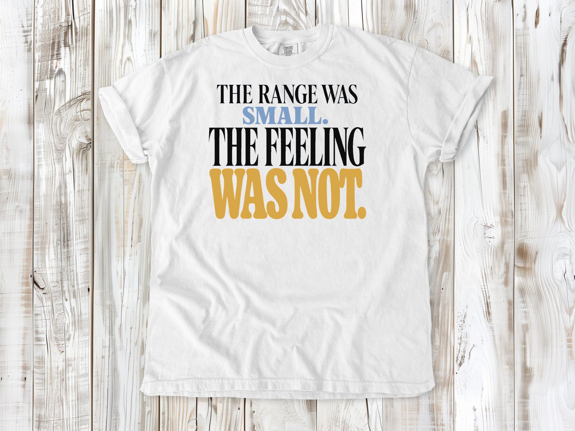 White garment-dyed tee with The Range Was Small The Feeling Was Not Pilates graphic.