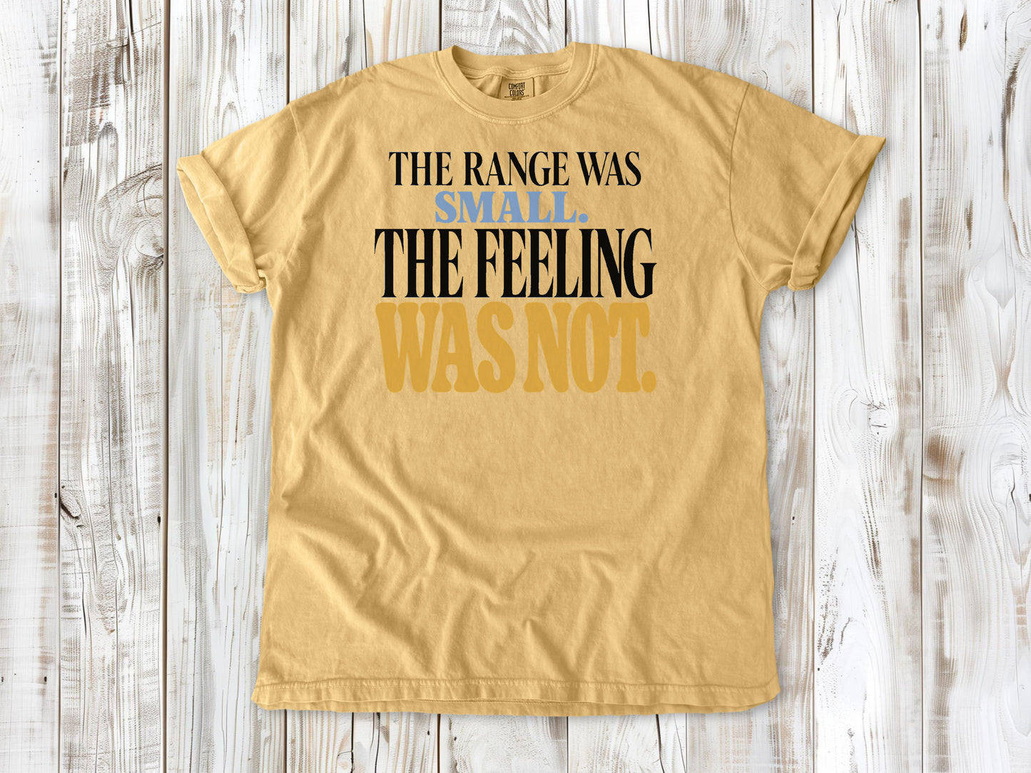 Mustard garment-dyed tee with The Range Was Small The Feeling Was Not Pilates graphic.