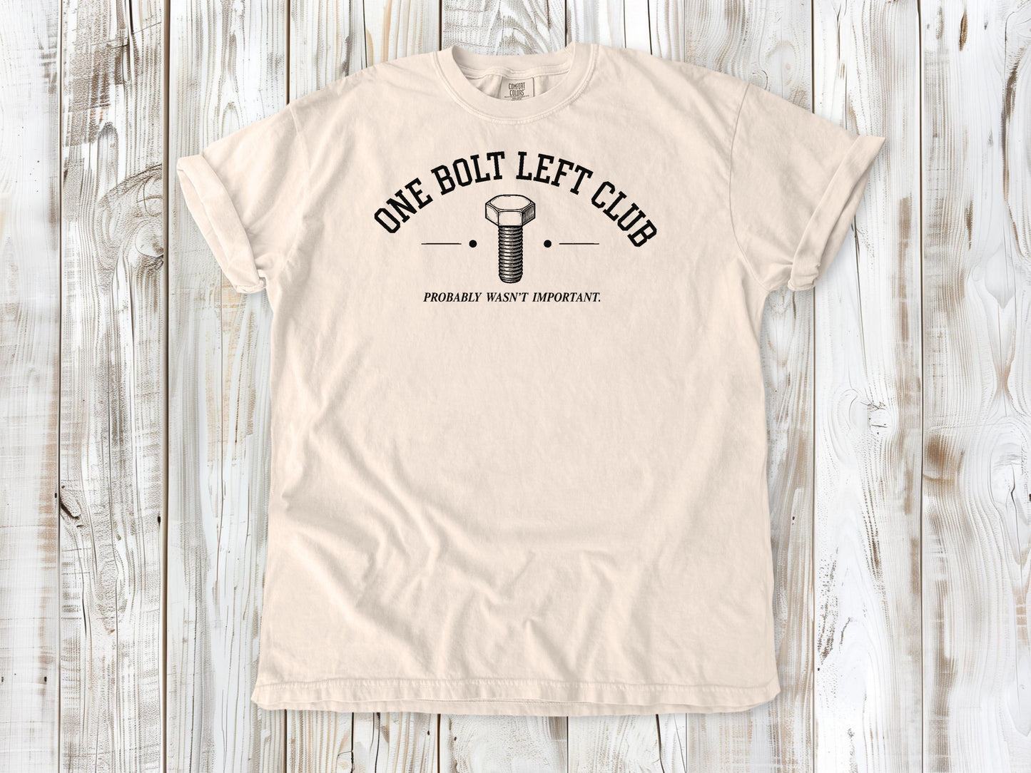 Ivory garment-dyed tee with One Bolt Left Club mechanic humor graphic.
