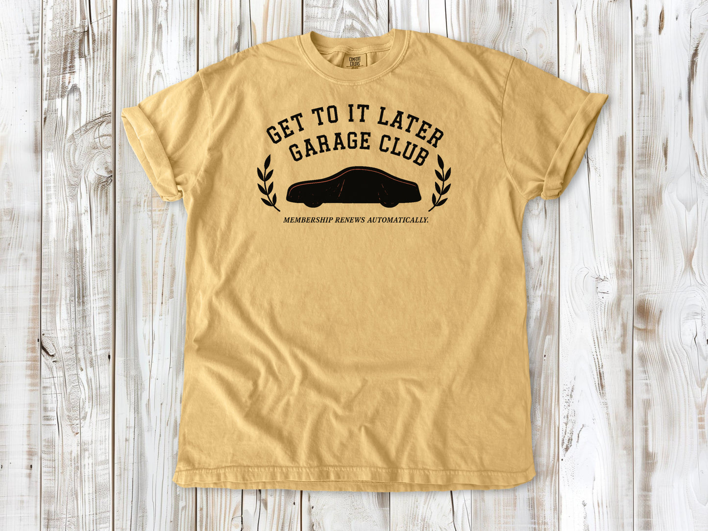 Mustard garment-dyed tee with Get to It Later Garage Club project humor graphic.